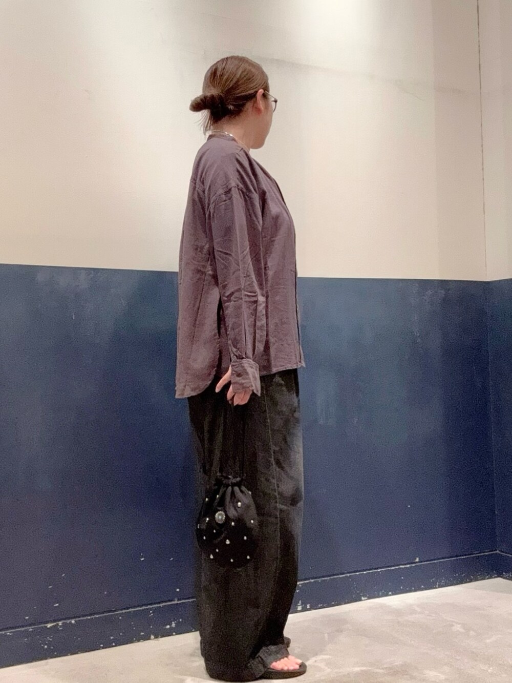 ブラック系のデニムパンツ、ブラック系のハンドバッグ、グレー系のシャツ/ブラウスを着用したレディースの夏コーディネートの2枚目の写真