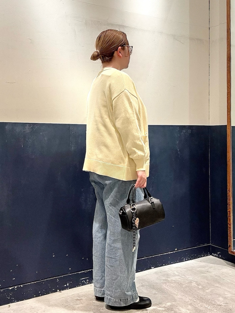 ブルー系のデニムパンツ、ブラック系のショルダーバッグ、グレー系のTシャツ/カットソーを着用したレディースの冬コーディネートの2枚目の写真