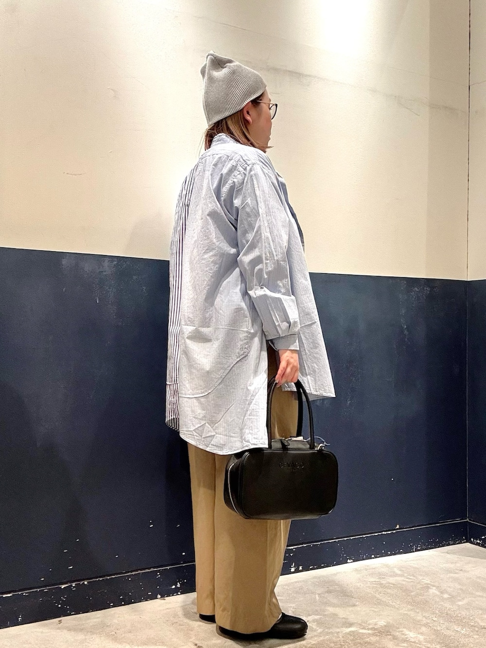 ブラック系のボストンバッグ、ベージュ系のデニムパンツ、ブルー系のシャツ/ブラウスを着用したレディースの冬コーディネートの2枚目の写真