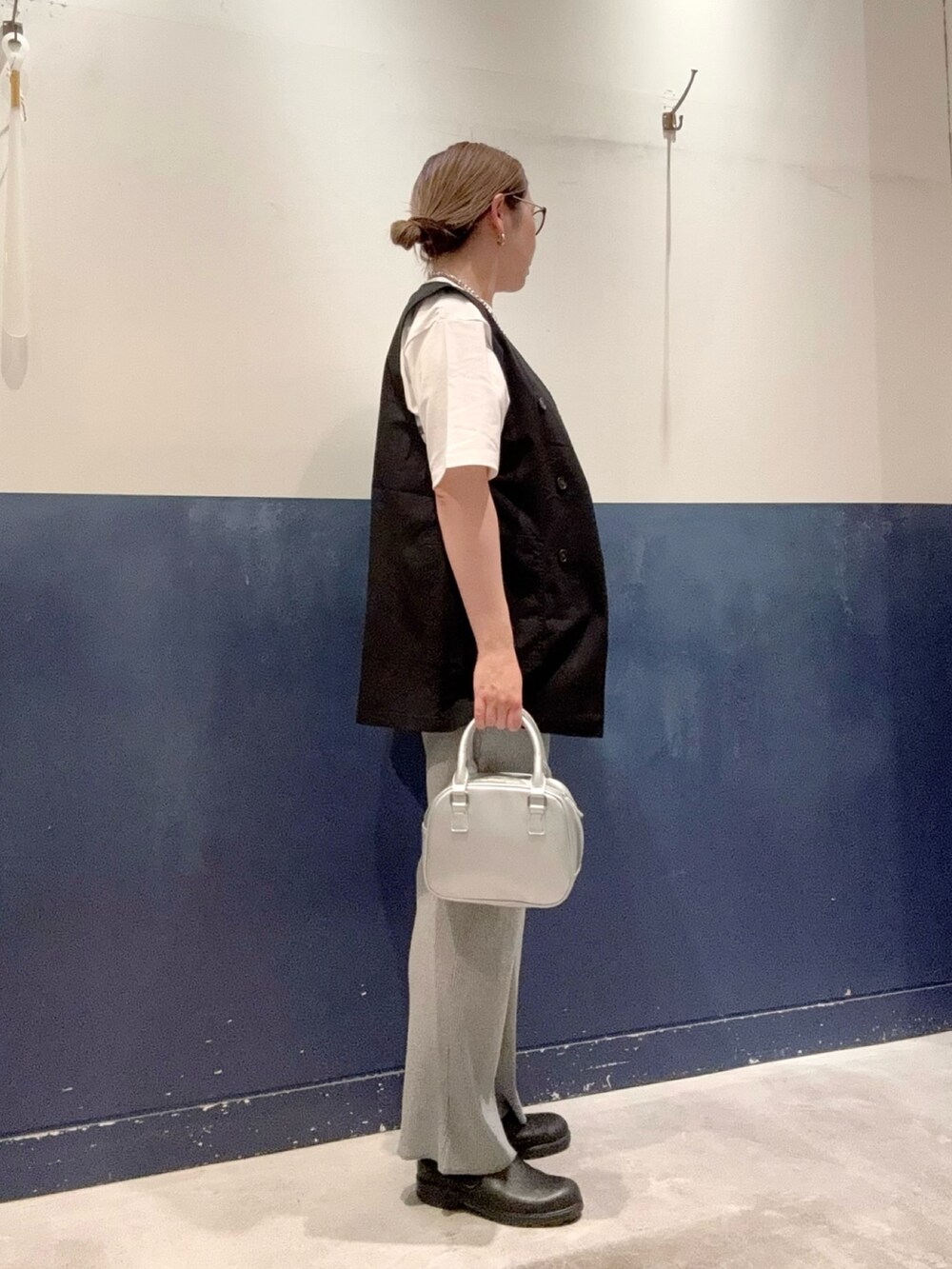 ホワイト系のTシャツ/カットソー、ブラック系のベスト、シルバー系のショルダーバッグを着用したレディースの春コーディネートの2枚目の写真