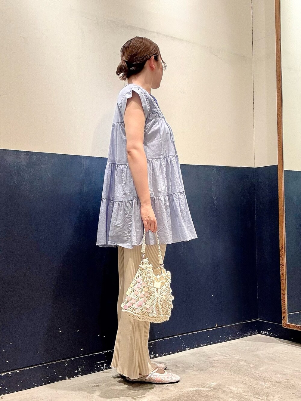 ホワイト系のパンプス、ホワイト系のショルダーバッグ、ホワイト系のスウェットパンツを着用したレディースの夏コーディネートの2枚目の写真
