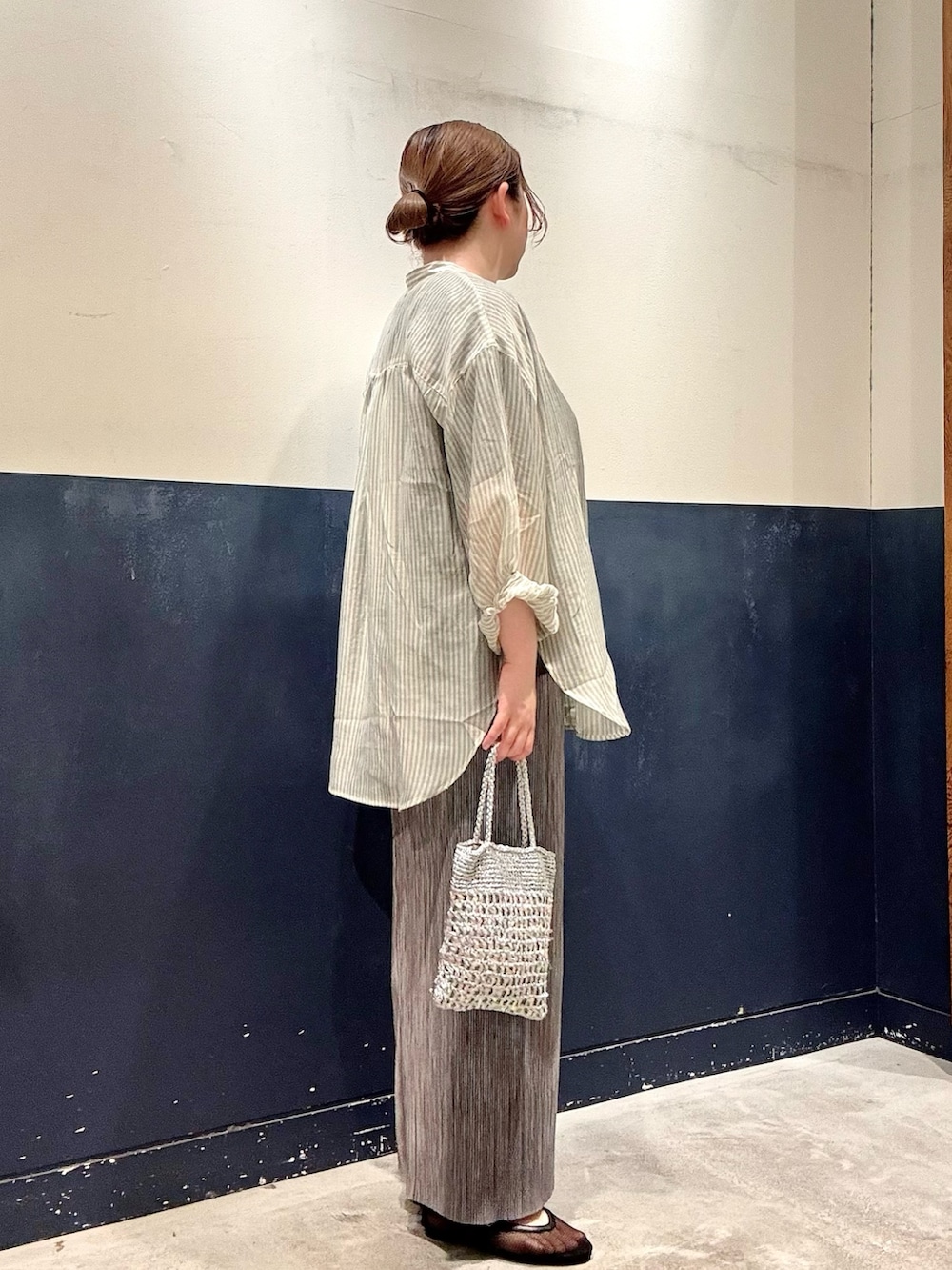 ブラック系のパンプス、シルバー系のショルダーバッグ、グリーン系のシャツ/ブラウスを着用したレディースの春コーディネートの2枚目の写真