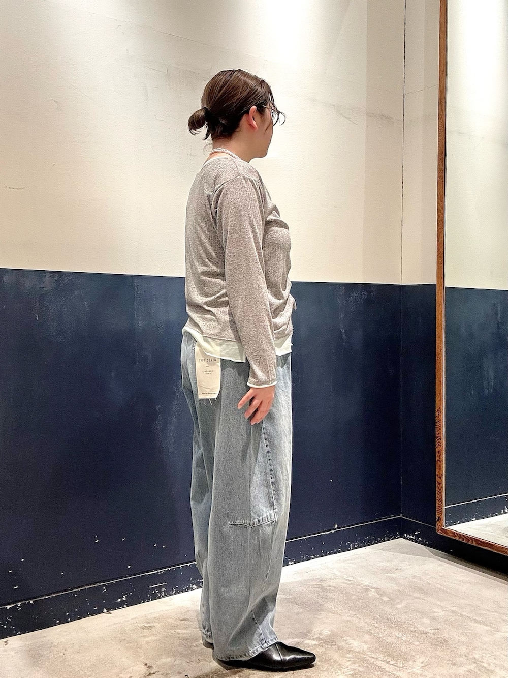 ブラック系のパンプス、ブルー系のデニムパンツ、グレー系のカーディガン/ボレロを着用したレディースの春コーディネートの2枚目の写真