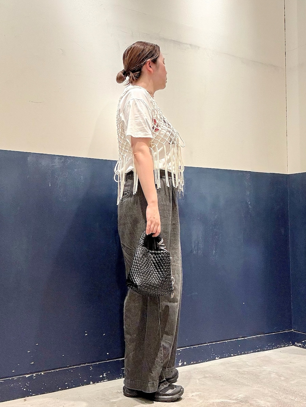 ブラック系のデニムパンツ、ブラック系のショルダーバッグ、ホワイト系のTシャツ/カットソーを着用したレディースの夏コーディネートの2枚目の写真