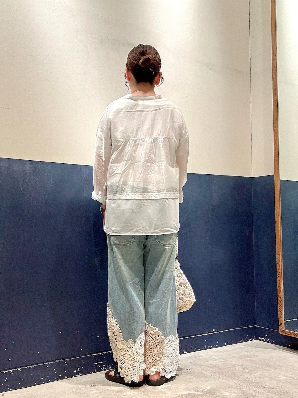 ブルー系のデニムパンツ、ホワイト系のショルダーバッグ、ホワイト系のTシャツ/カットソーを着用したレディースの夏コーディネートの3枚目の写真