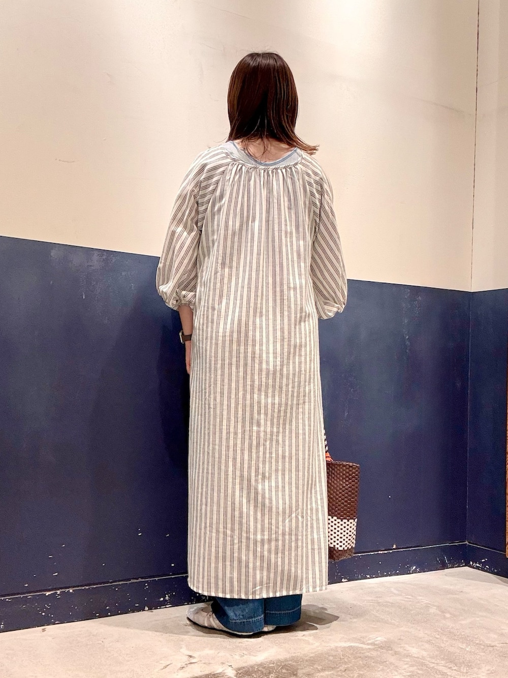 ホワイト系のパンプス、ブルー系のデニムパンツ、ブラウン系のトートバッグを着用したレディースの夏コーディネートの3枚目の写真