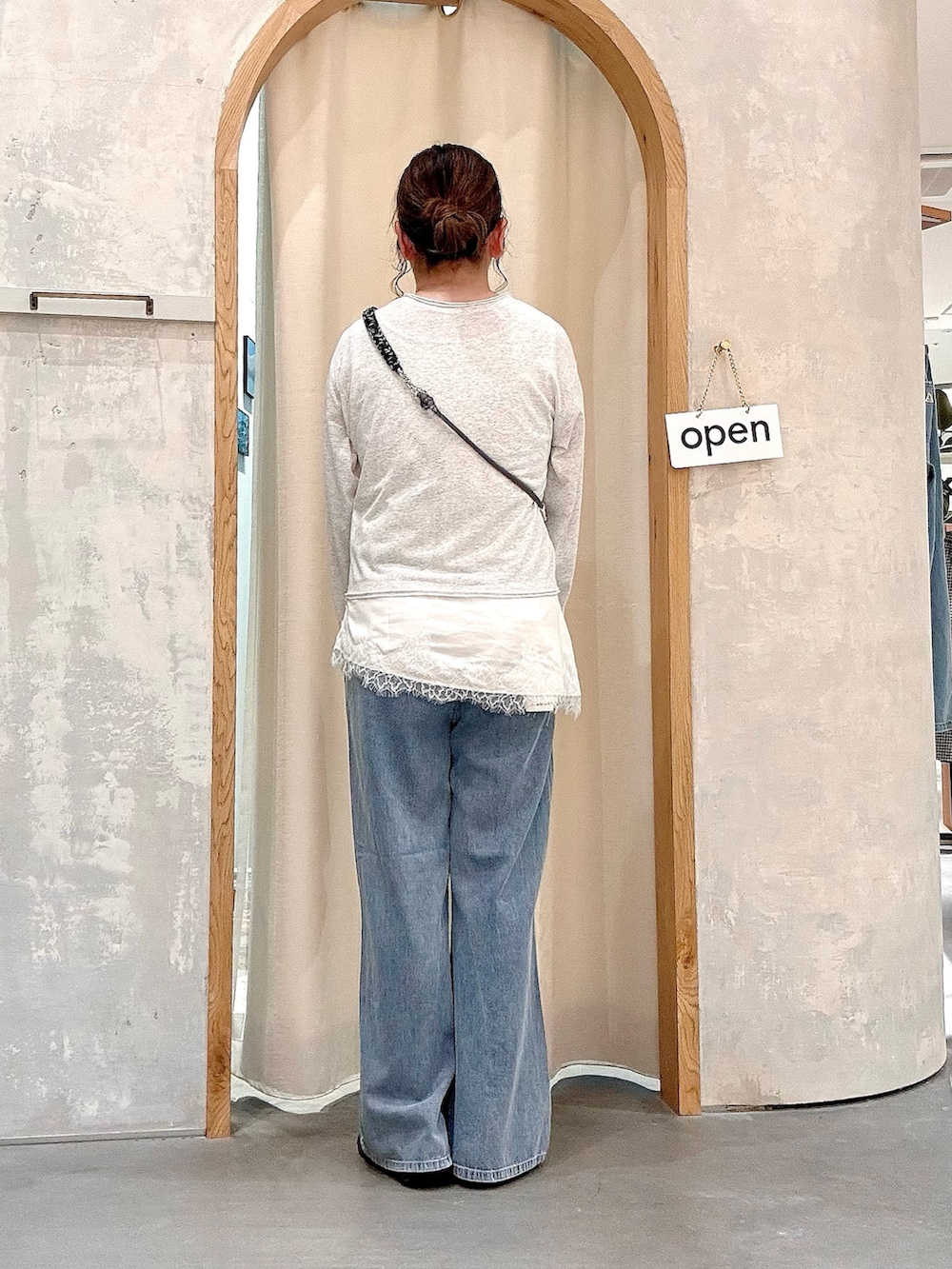 ブルー系のデニムパンツ、ホワイト系のTシャツ/カットソー、ブラック系のスマホグッズを着用したレディースの夏コーディネートの3枚目の写真