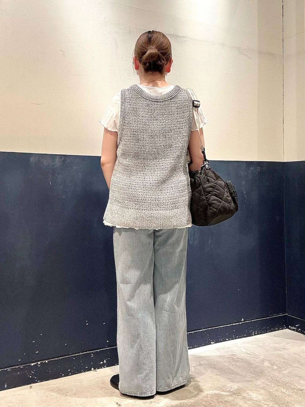 ブルー系のデニムパンツ、ブラック系のショルダーバッグ、ホワイト系のTシャツ/カットソーを着用したレディースの春コーディネートの3枚目の写真