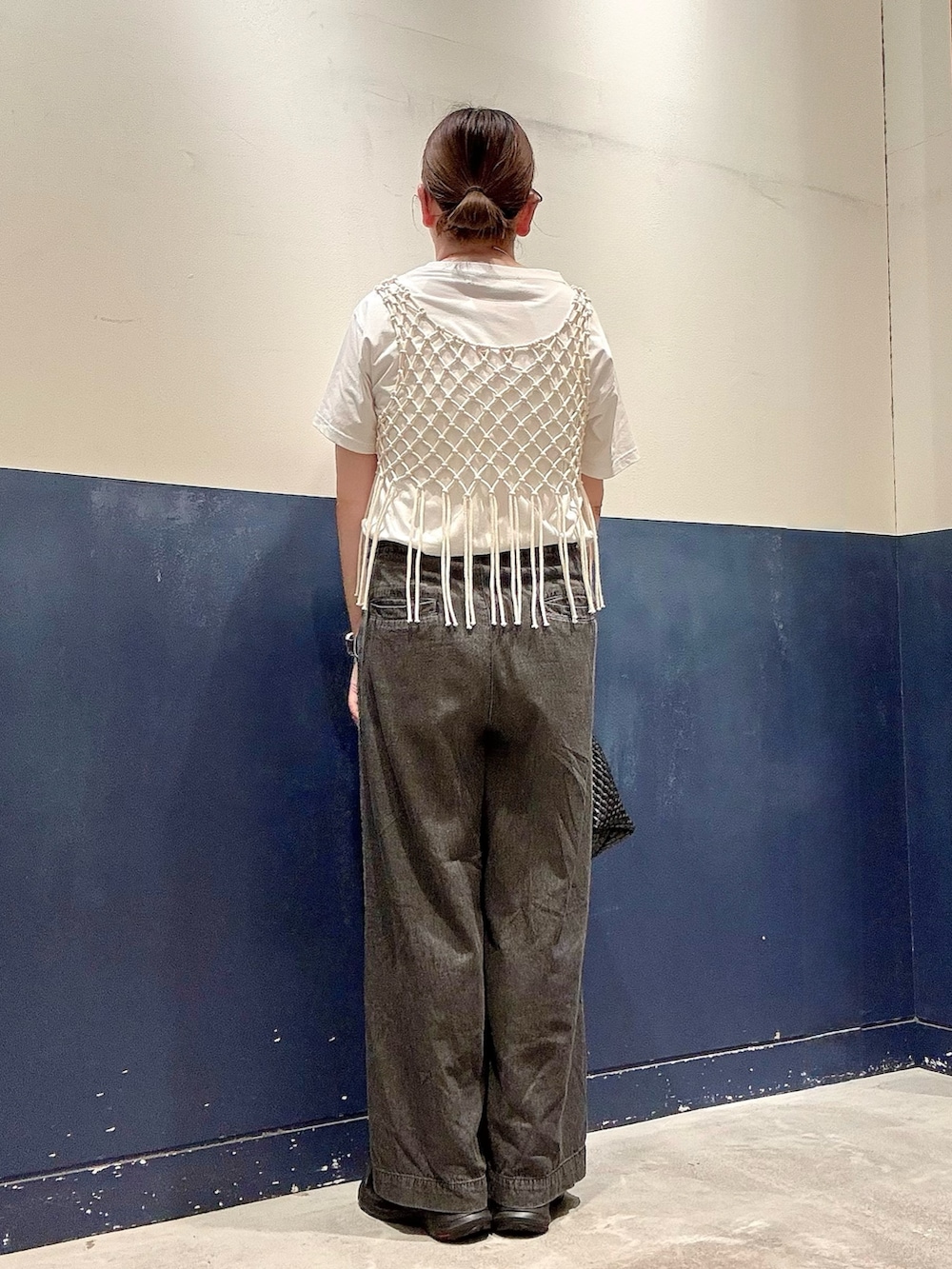 ブラック系のデニムパンツ、ブラック系のショルダーバッグ、ホワイト系のTシャツ/カットソーを着用したレディースの夏コーディネートの3枚目の写真