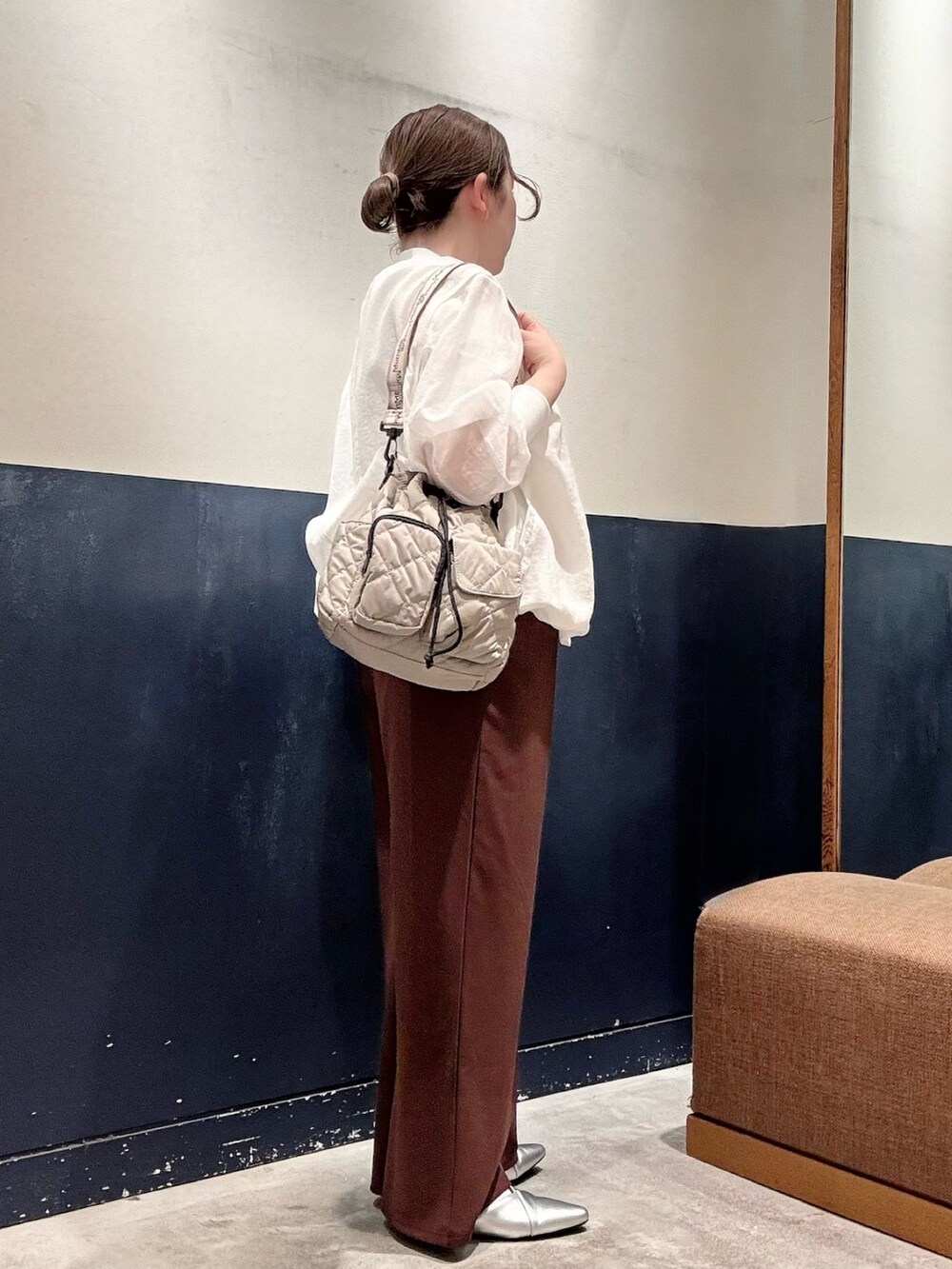 シルバー系のパンプス、ホワイト系のTシャツ/カットソー、ブラウン系のスラックスを着用したレディースの春コーディネートの2枚目の写真