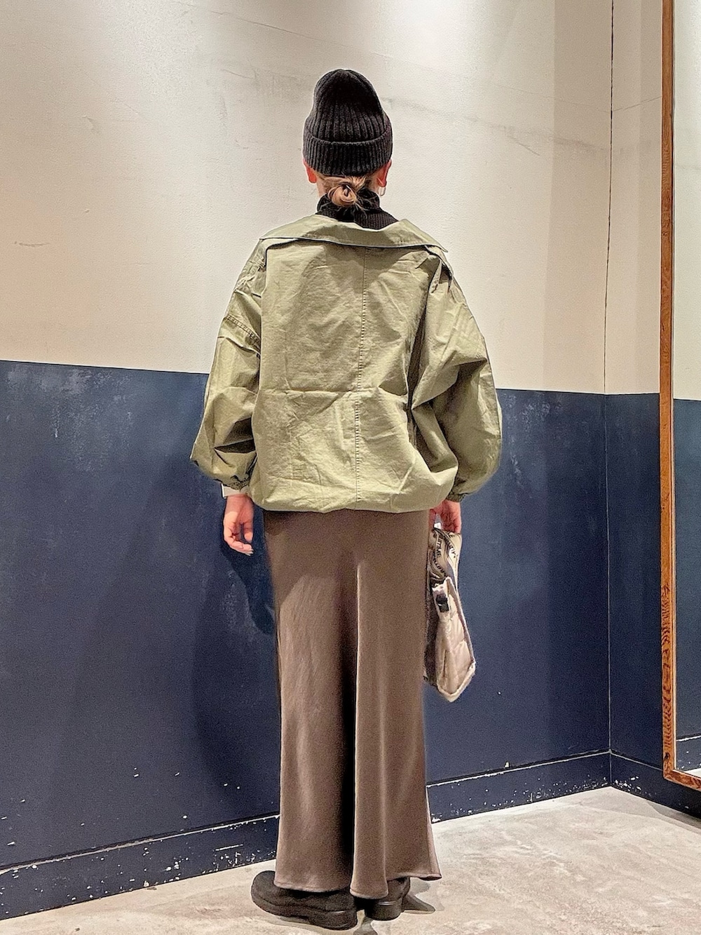 ブラック系のニット/セーター、グリーン系のブルゾン、グレー系のショルダーバッグを着用したレディースの冬コーディネートの3枚目の写真