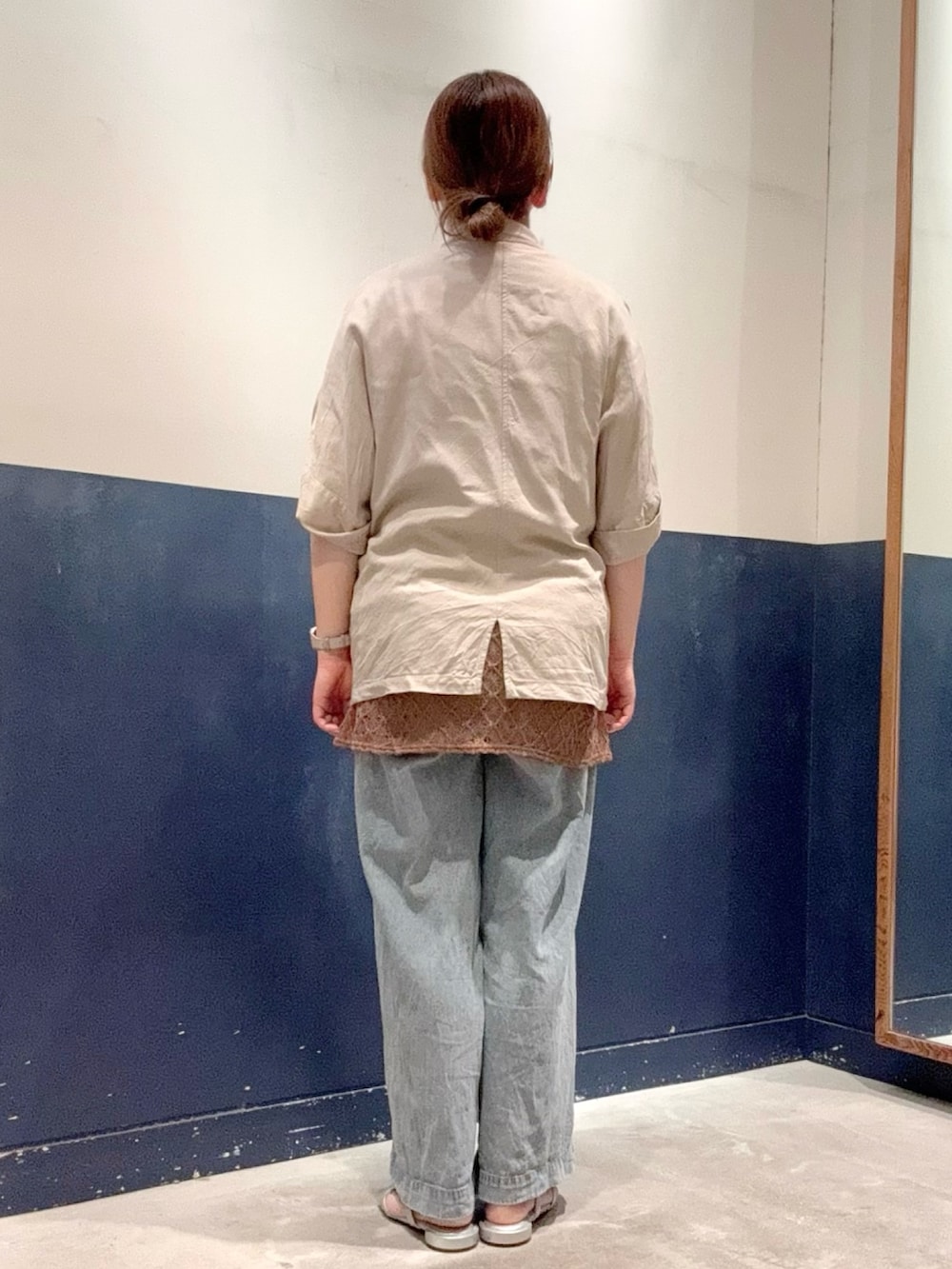 ブラウン系のキャミソール、ベージュ系のテーラードジャケット、ブルー系のデニムパンツを着用したレディースの夏コーディネートの3枚目の写真