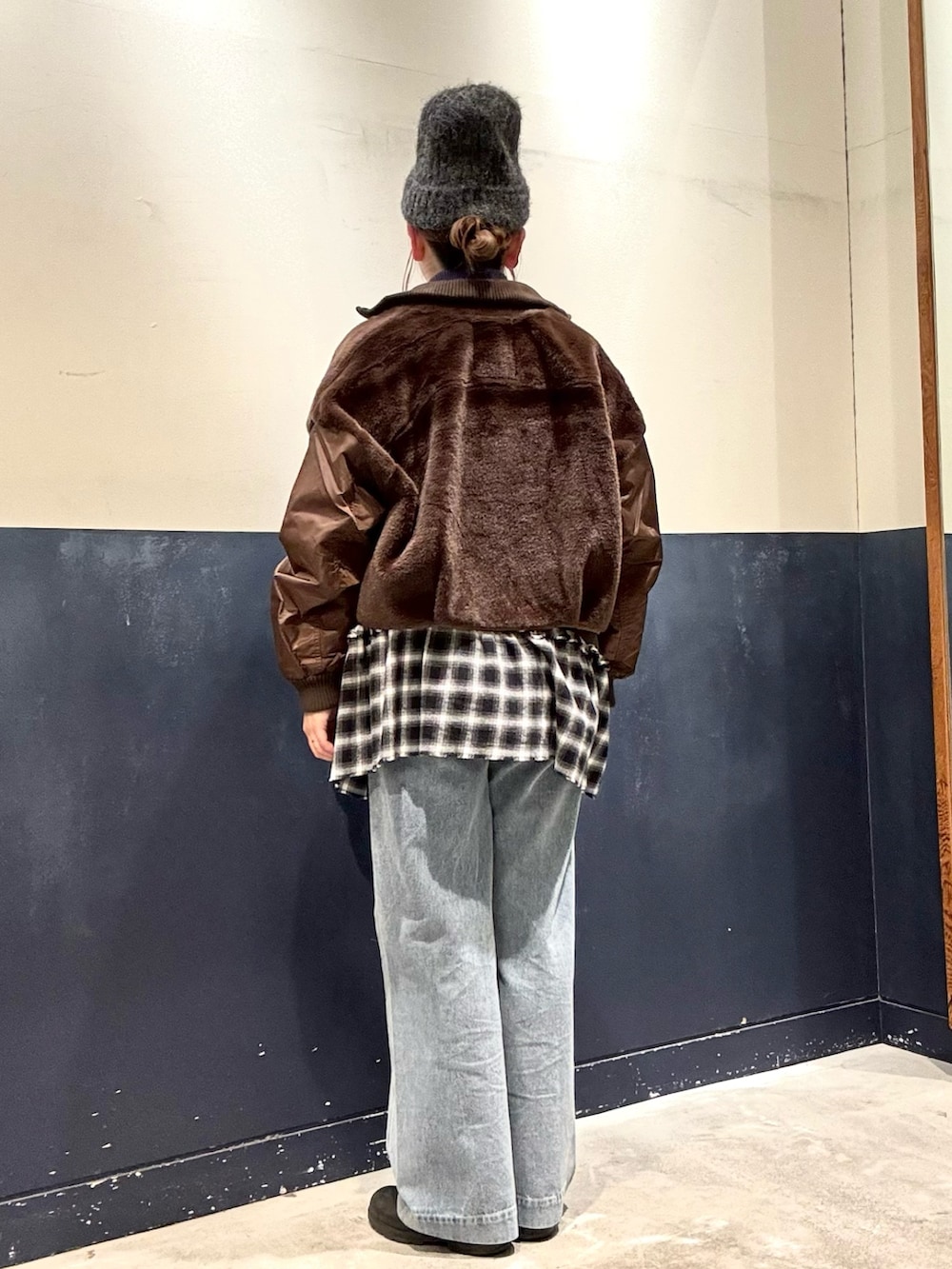 ブラウン系のブルゾン、パープル系のニット/セーター、グレー系のTシャツ/カットソーを着用したレディースの冬コーディネートの3枚目の写真