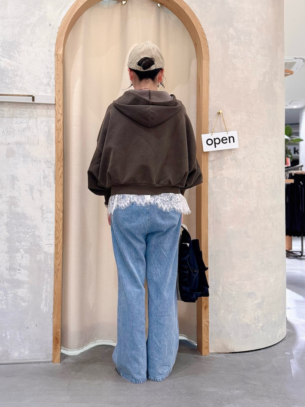 ブルー系のデニムパンツ、ブラウン系のパーカー、ホワイト系のTシャツ/カットソーを着用したレディースの秋コーディネートの3枚目の写真