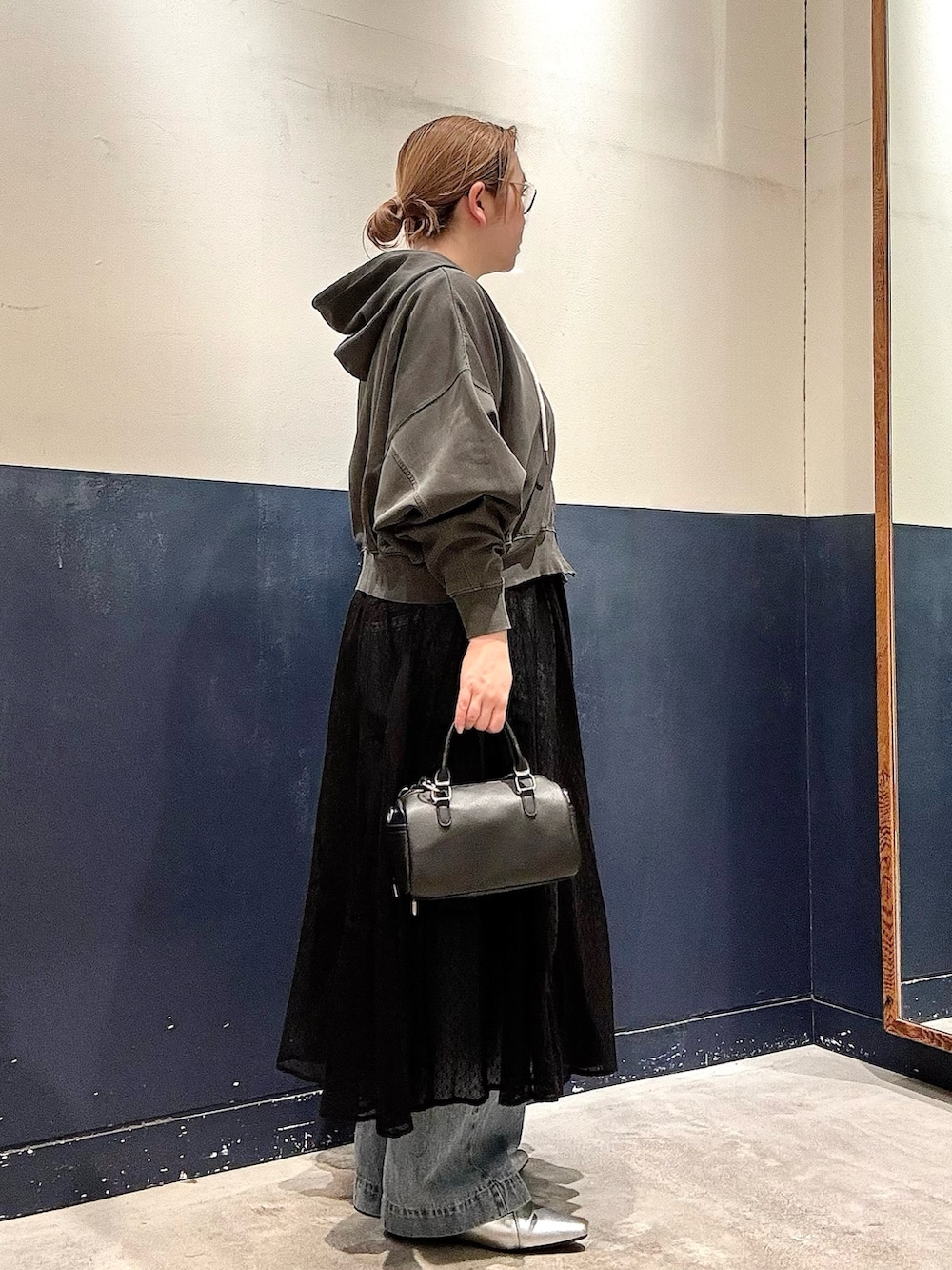 ブラック系のワンピース、ブラック系のショルダーバッグ、シルバー系のパンプスを着用したレディースの春コーディネートの2枚目の写真