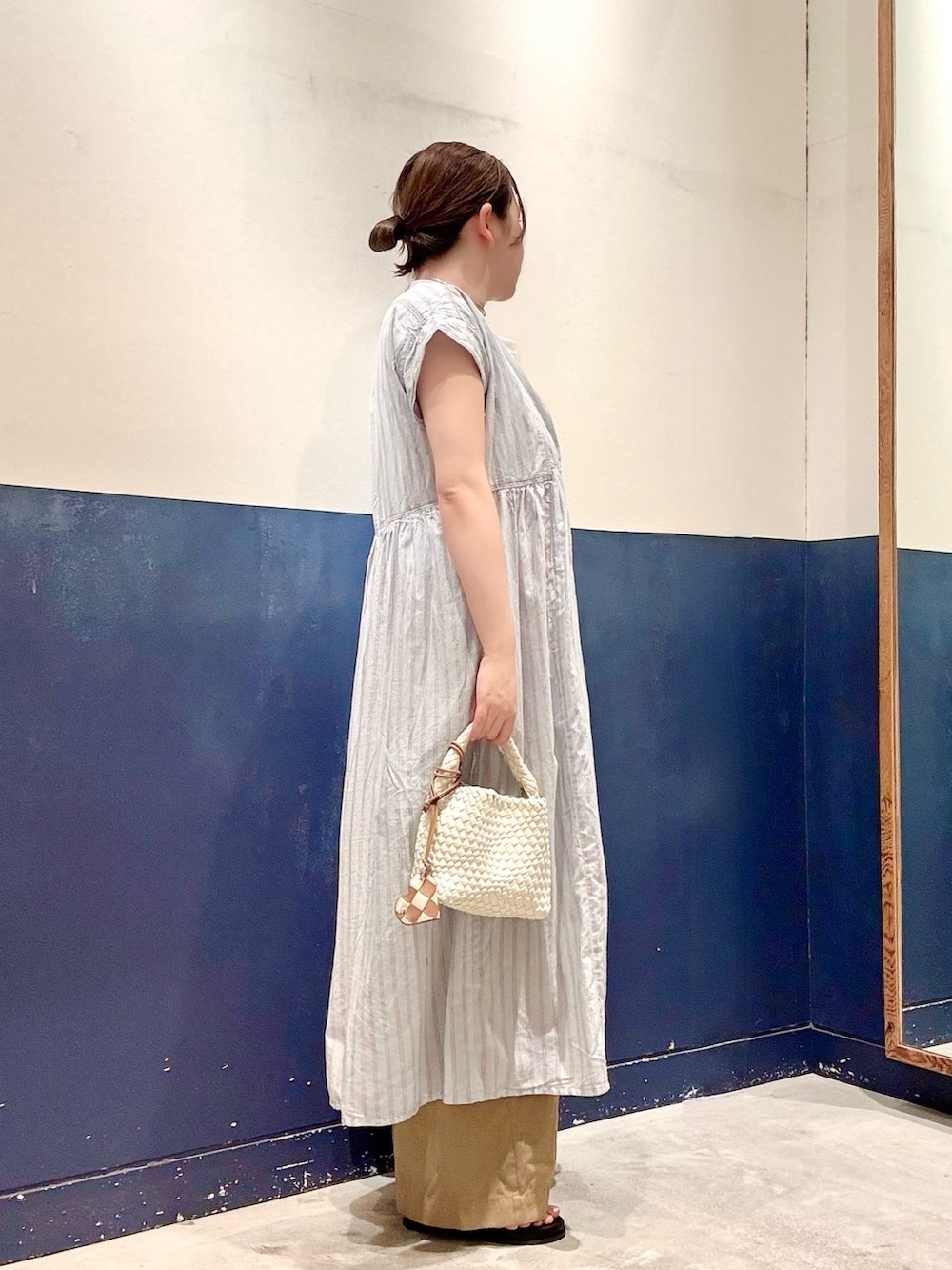 イエロー系のサンダル、ブルー系のワンピース、ホワイト系のTシャツ/カットソーを着用したレディースの夏コーディネートの2枚目の写真