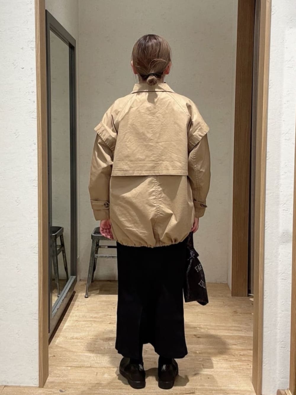 ブラック系のスカート、ベージュ系のトレンチコート、ブラウン系のシャツ/ブラウスを着用したレディースの春コーディネートの3枚目の写真