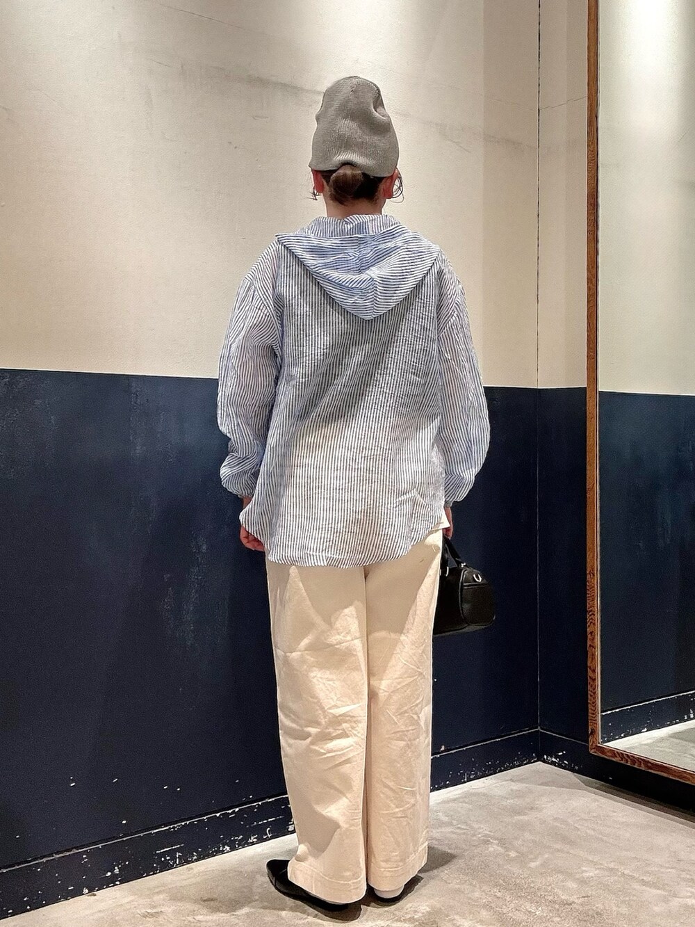 ブラック系のパンプス、ブラック系のショルダーバッグ、ホワイト系のデニムパンツを着用したレディースの春コーディネートの3枚目の写真