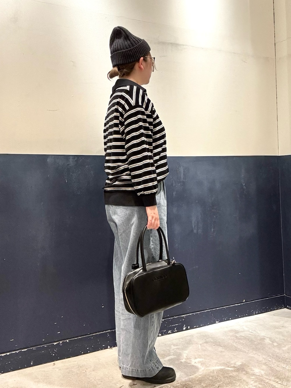 ブラック系のボストンバッグ、ブルー系のデニムパンツ、ブラック系のTシャツ/カットソーを着用したレディースの冬コーディネートの2枚目の写真