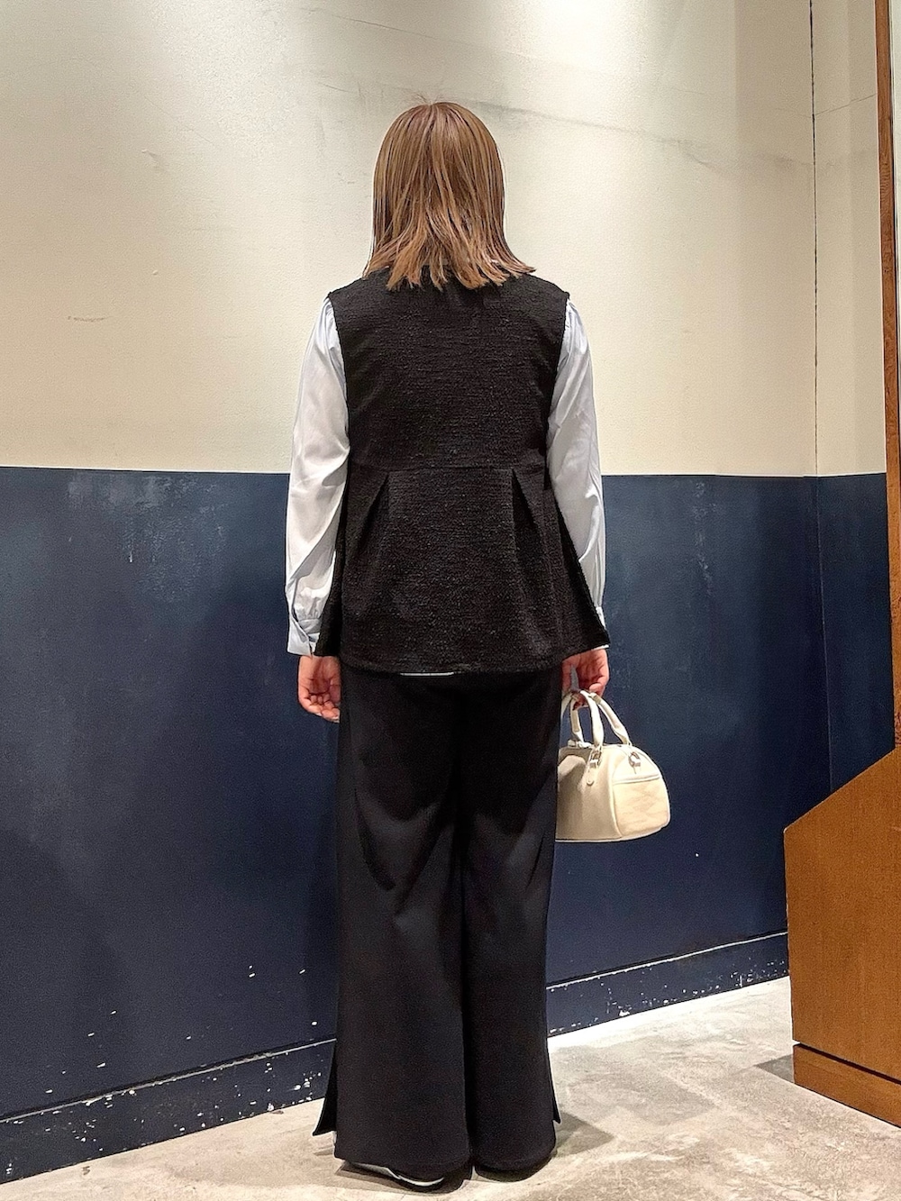 シルバー系のパンプス、ホワイト系のショルダーバッグ、ブルー系のシャツ/ブラウスを着用したレディースの冬コーディネートの3枚目の写真