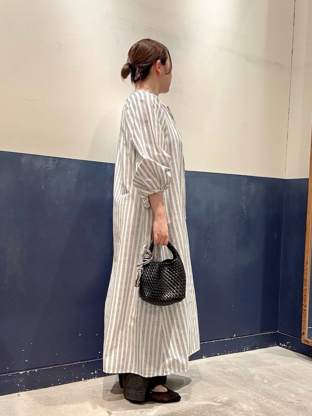 ブラック系のショルダーバッグ、ブラック系のパンプス、ブラック系のデニムパンツを着用したレディースの夏コーディネートの2枚目の写真