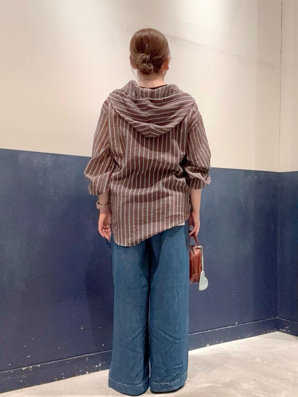 ブラウン系のタンクトップ、ブラウン系のトートバッグ、ブルー系のパンプスを着用したレディースの夏コーディネートの3枚目の写真