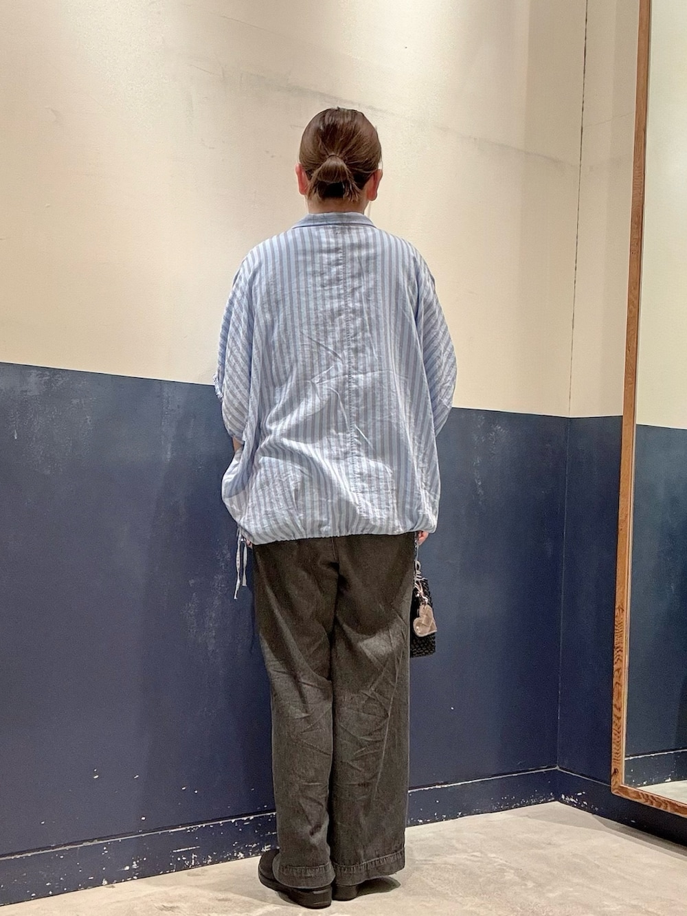 ブラック系のショルダーバッグ、ブラック系のデニムパンツ、ブルー系のシャツ/ブラウスを着用したレディースの夏コーディネートの3枚目の写真