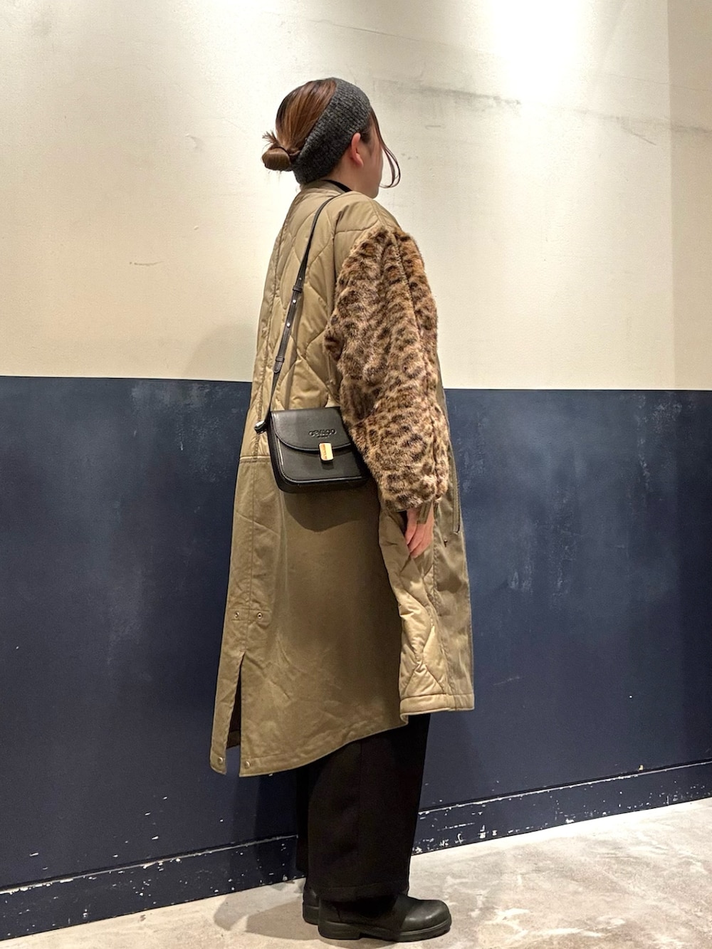 ブラック系のその他パンツ、ブラック系のニット/セーター、グリーン系のノーカラーコートを着用したレディースの冬コーディネートの2枚目の写真