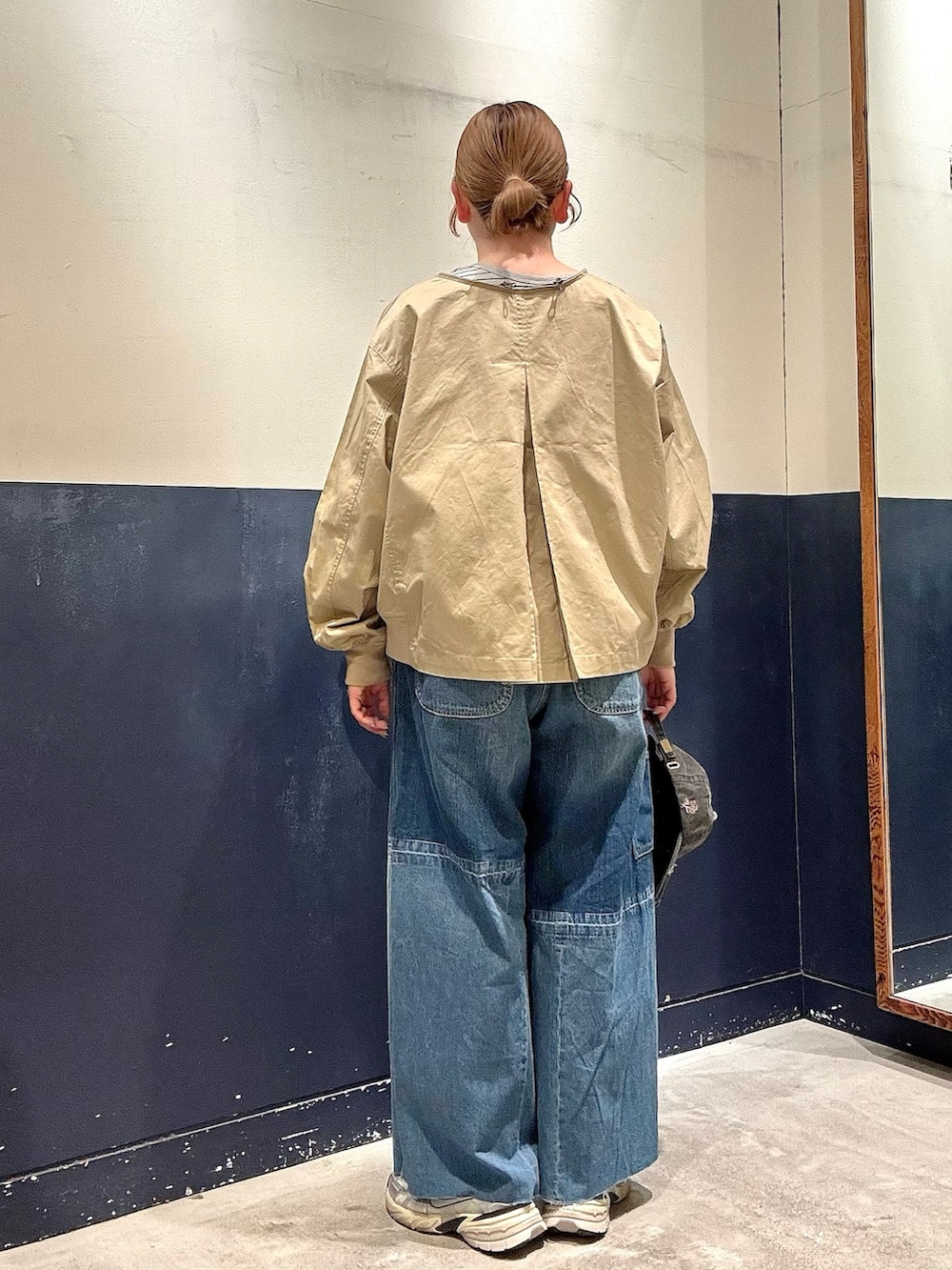 ブルー系のデニムパンツ、ベージュ系のトレンチコート、グレー系のTシャツ/カットソーを着用したレディースの春コーディネートの3枚目の写真