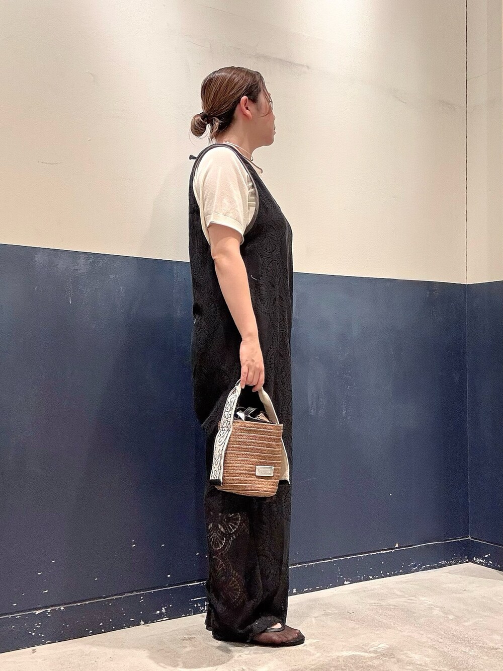 ブラウン系のトートバッグ、ブラック系のパンプス、ホワイト系のニット/セーターを着用したレディースの夏コーディネートの2枚目の写真