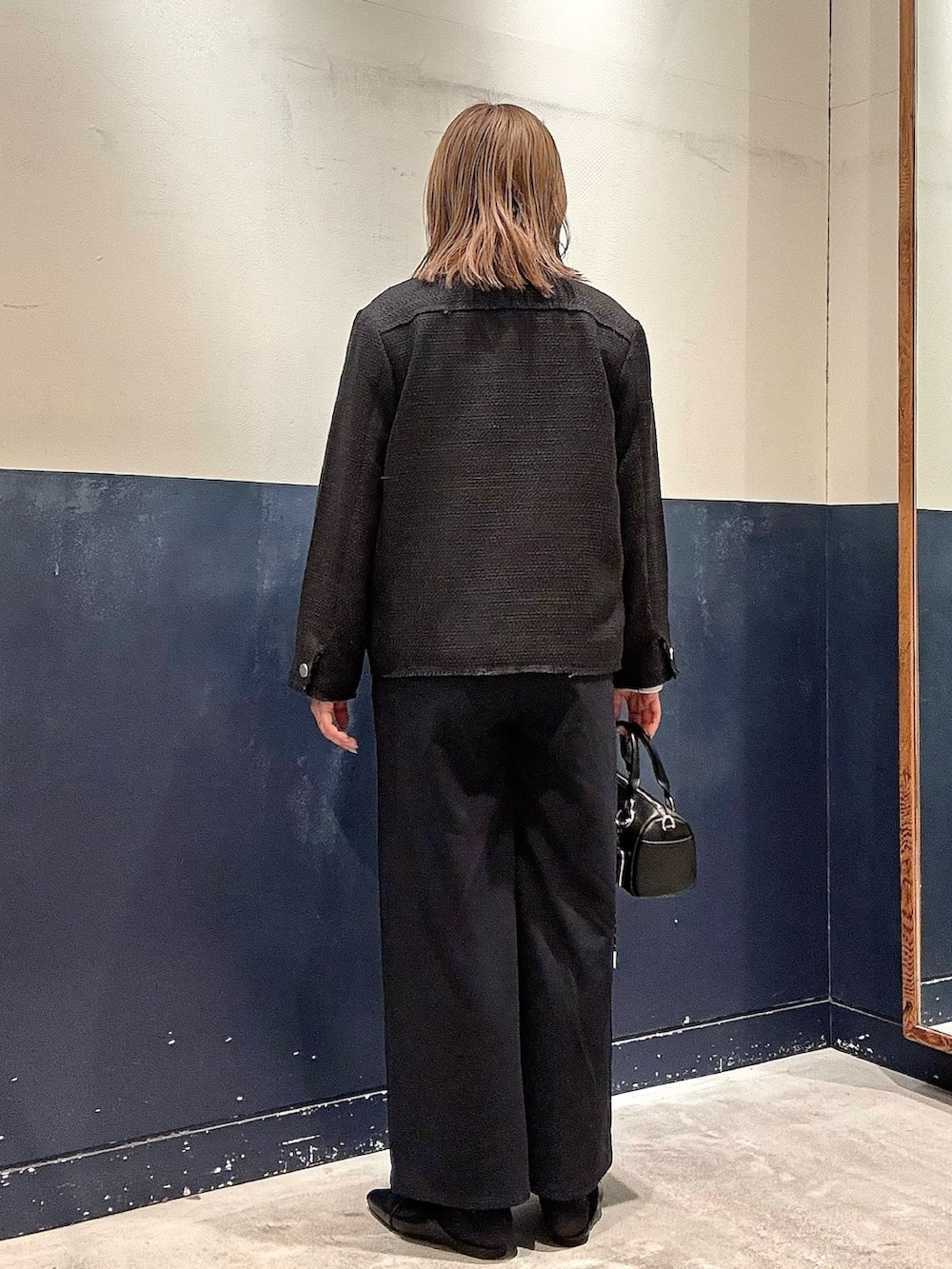 ブラック系のパンプス、ブラック系のショルダーバッグ、ブルー系のサロペット/オーバーオールを着用したレディースの冬コーディネートの3枚目の写真