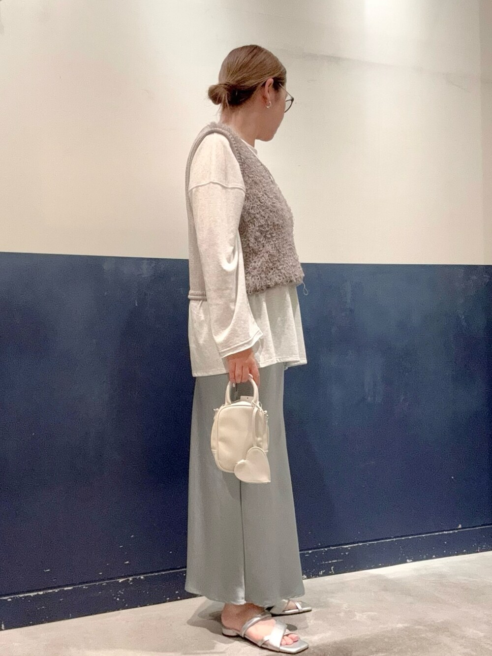 グレー系のベスト、グレー系のTシャツ/カットソー、ホワイト系のトートバッグを着用したレディースの秋コーディネートの2枚目の写真