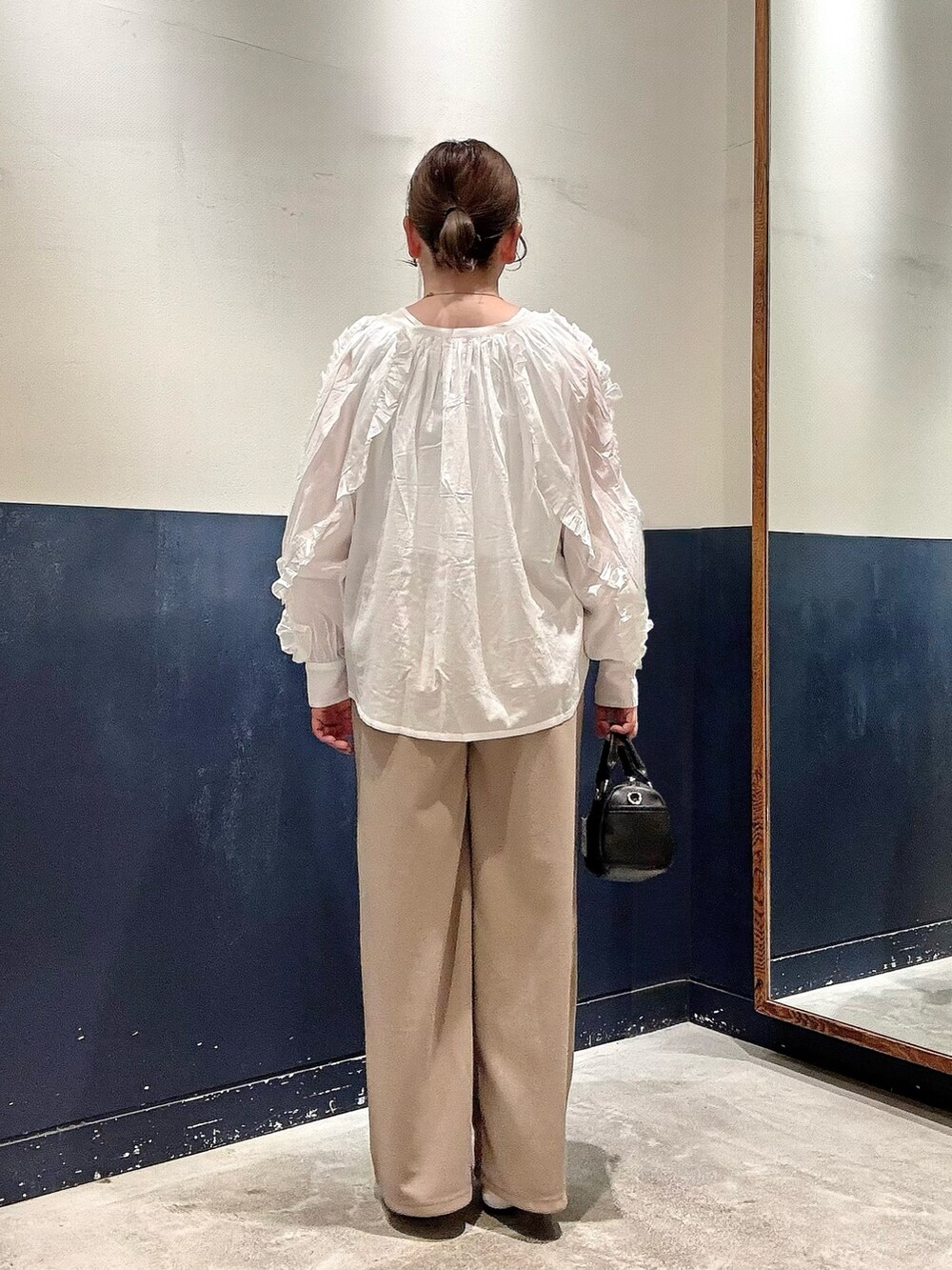 ブラック系のパンプス、ブラック系のショルダーバッグ、ホワイト系のタンクトップを着用したレディースの春コーディネートの3枚目の写真