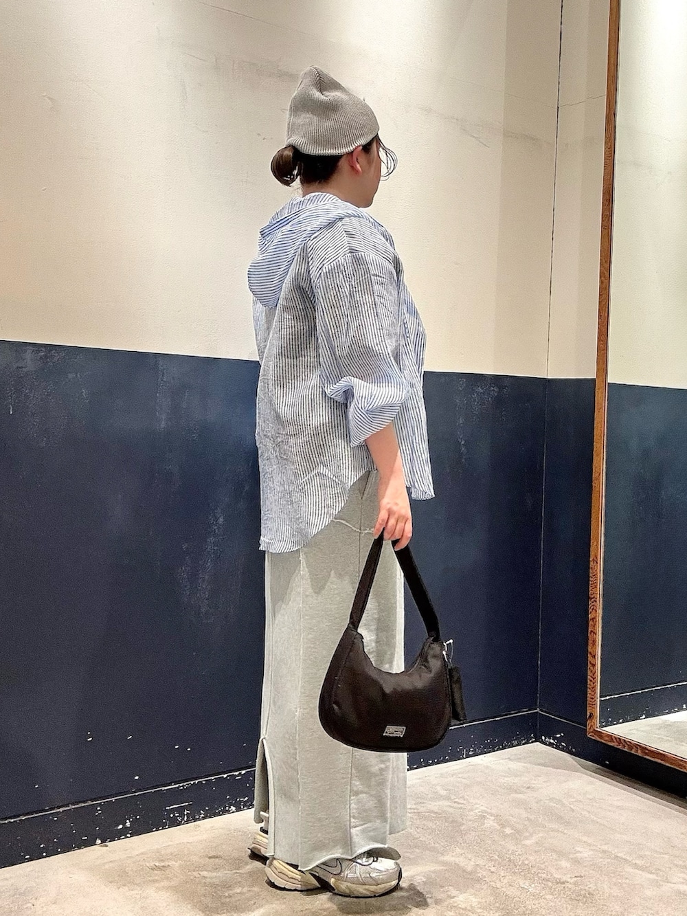 ブルー系のシャツ/ブラウス、ブラック系のショルダーバッグ、グレー系のTシャツ/カットソーを着用したレディースの春コーディネートの2枚目の写真