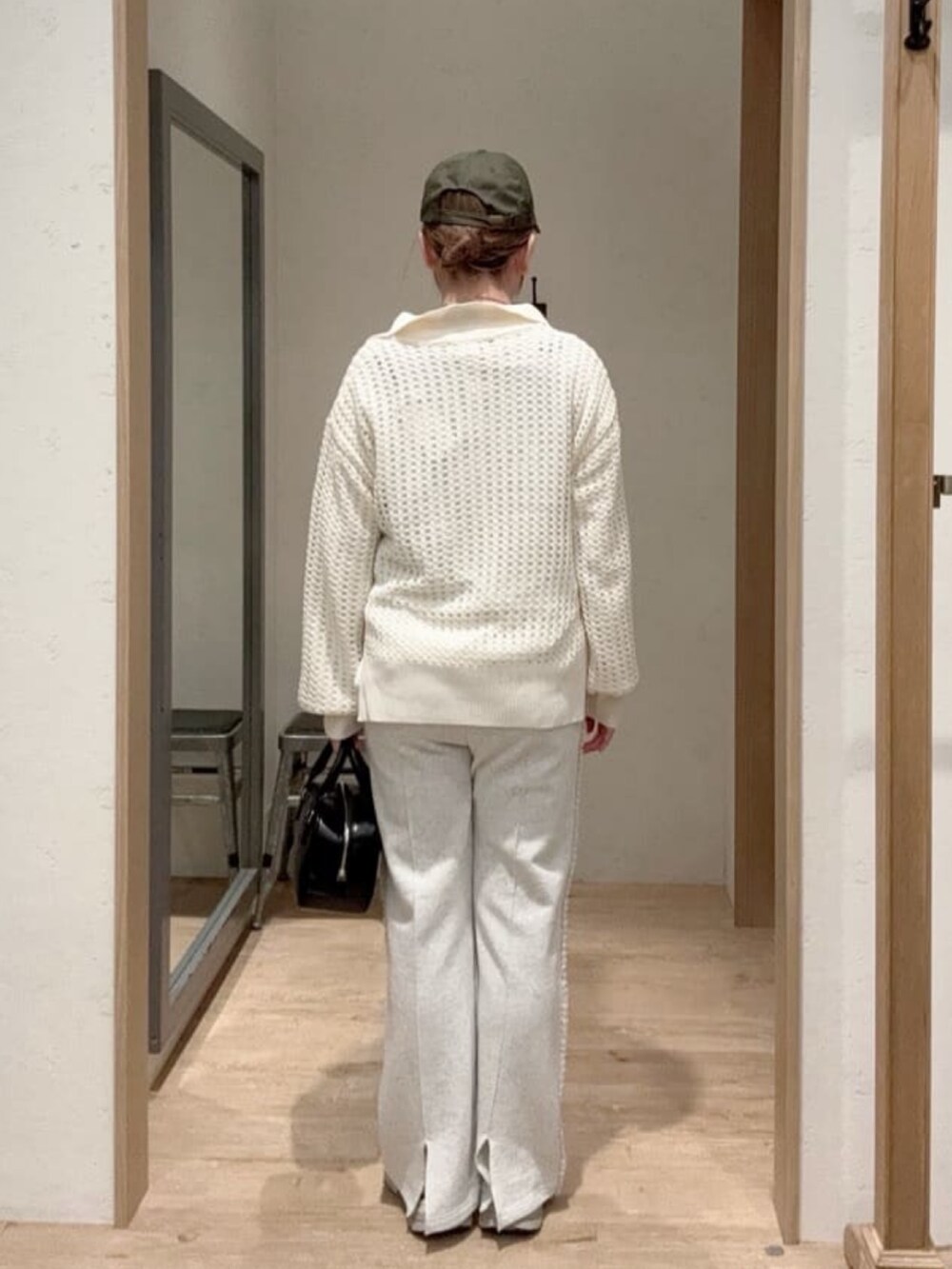 ホワイト系のニット/セーター、ホワイト系のTシャツ/カットソー、ブラック系のショルダーバッグを着用したレディースの春コーディネートの3枚目の写真