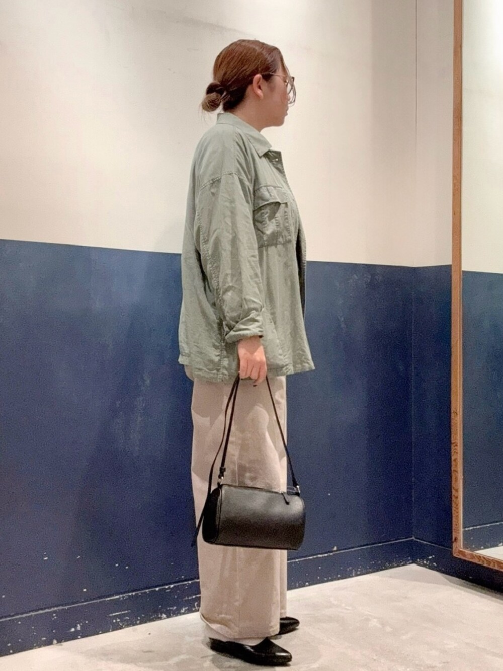 グリーン系のシャツ/ブラウス、ブラウン系のTシャツ/カットソー、ブラック系のショルダーバッグを着用したレディースの秋コーディネートの2枚目の写真