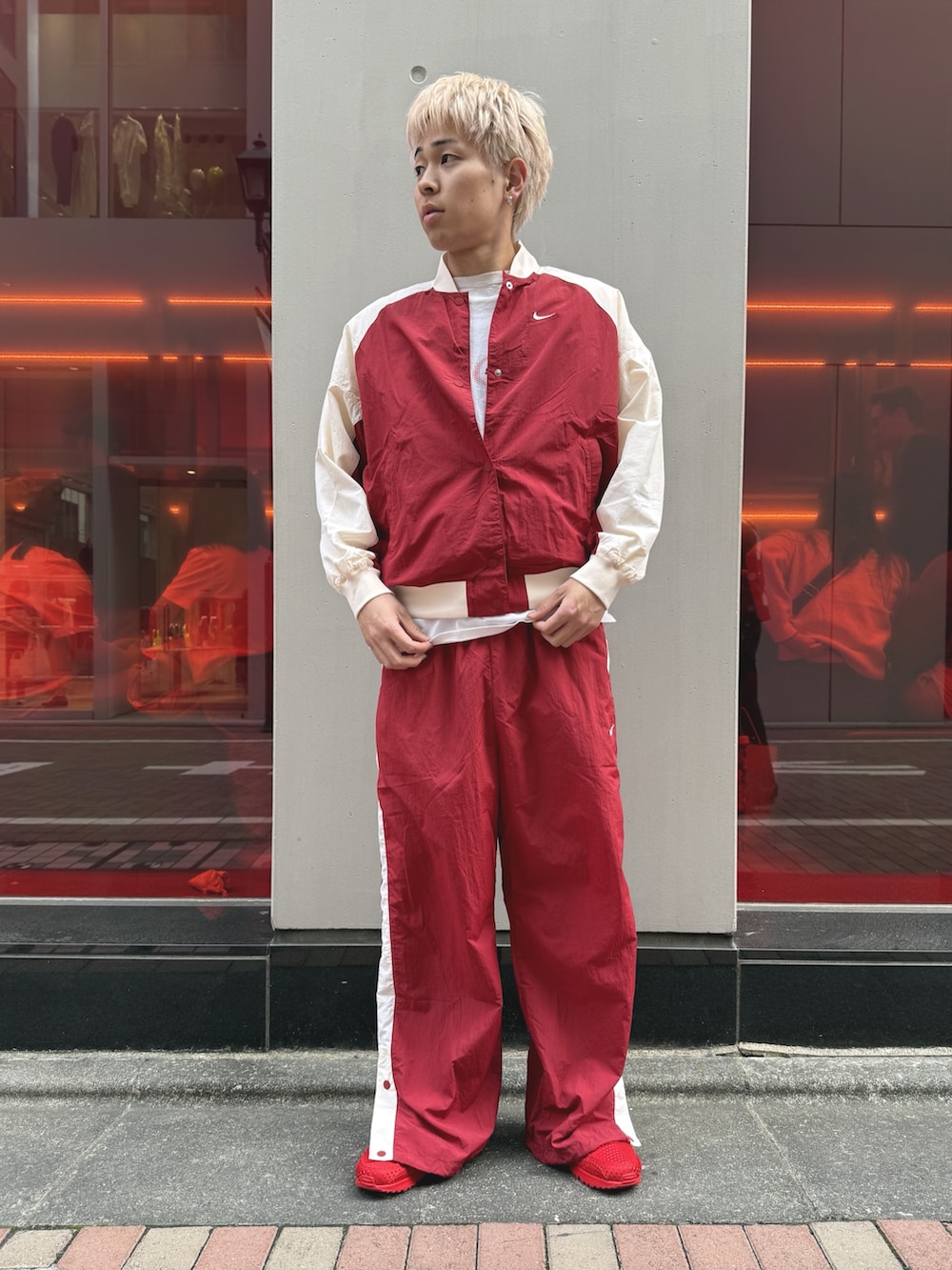 レッド系のブルゾン、レッド系のスニーカーを着用したメンズの春コーディネートの3枚目の写真