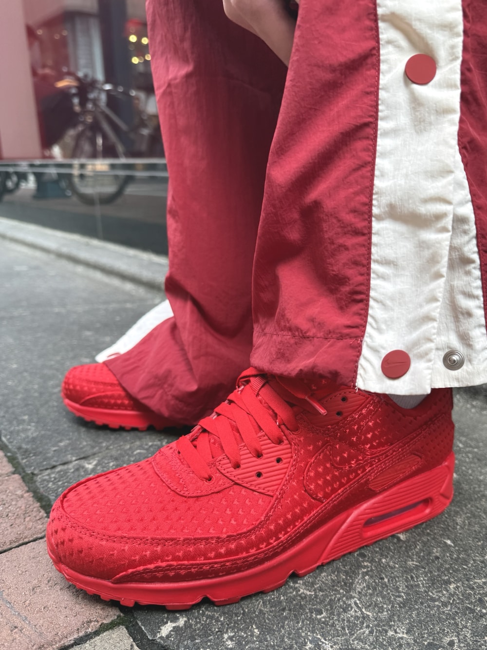 レッド系のブルゾン、レッド系のスニーカーを着用したメンズの春コーディネートの4枚目の写真