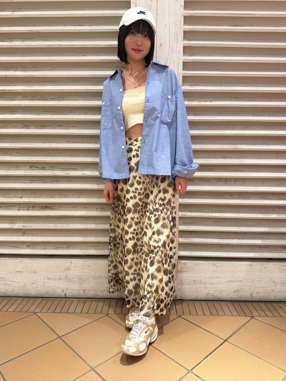 ブルー系のシャツ/ブラウス、ベージュ系のスニーカー、ホワイト系のキャップを着用したレディースの夏コーディネートの2枚目の写真