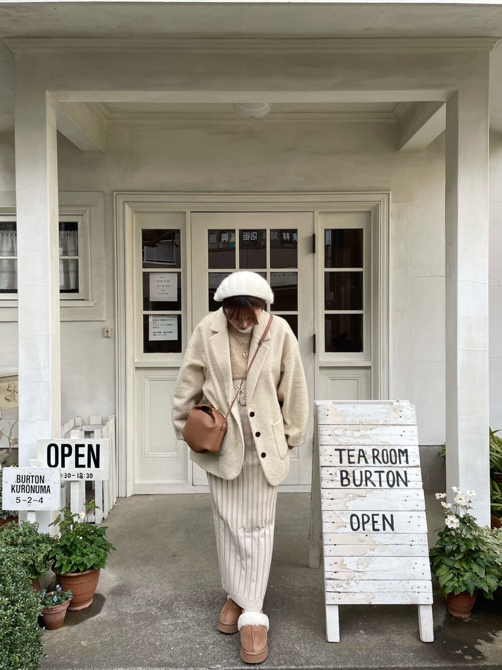 ホワイト系のスカート、ブラウン系のショルダーバッグ、ホワイト系のジャケット/アウターを着用したレディースの冬コーディネートの2枚目の写真