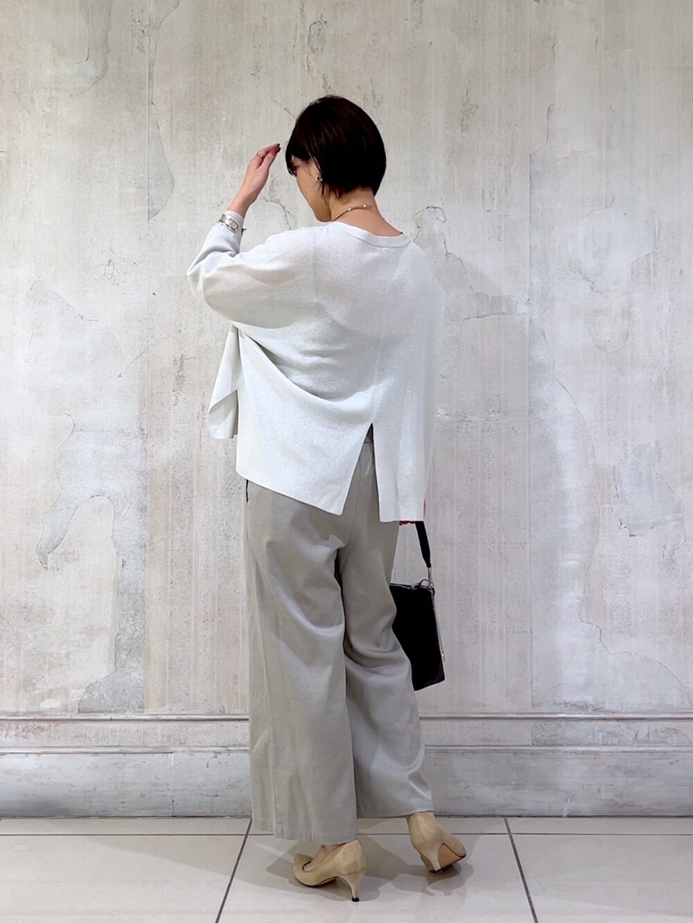 グレー系のその他パンツ、シルバー系のカーディガン/ボレロ、ブラック系のショルダーバッグを着用したレディースの秋コーディネートの3枚目の写真