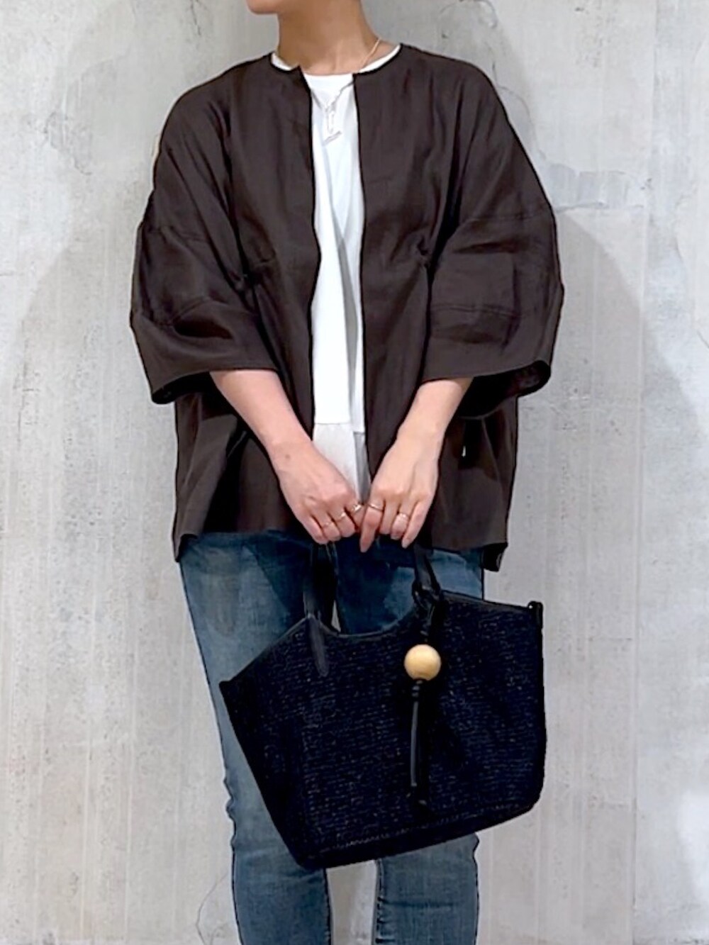 グレー系のブルゾン、ホワイト系のTシャツ/カットソー、ブルー系のデニムパンツを着用したレディースの夏コーディネートの6枚目の写真