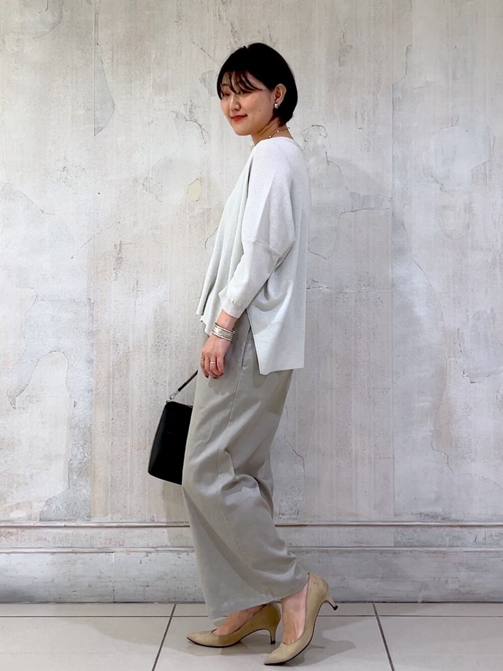 グレー系のその他パンツ、シルバー系のカーディガン/ボレロ、ブラック系のショルダーバッグを着用したレディースの秋コーディネートの2枚目の写真