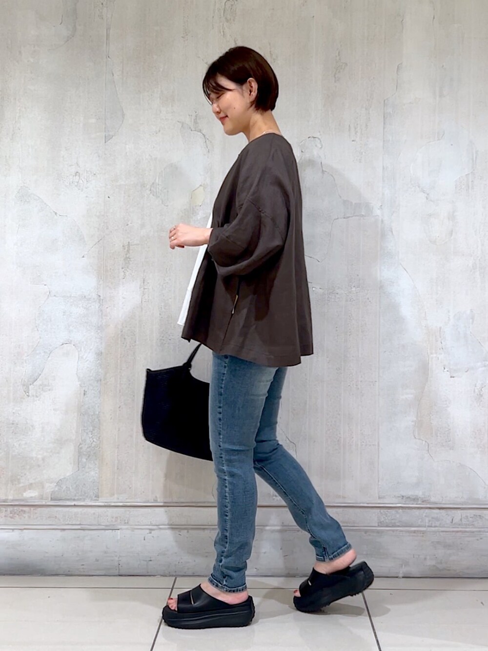 グレー系のブルゾン、ホワイト系のTシャツ/カットソー、ブルー系のデニムパンツを着用したレディースの夏コーディネートの4枚目の写真