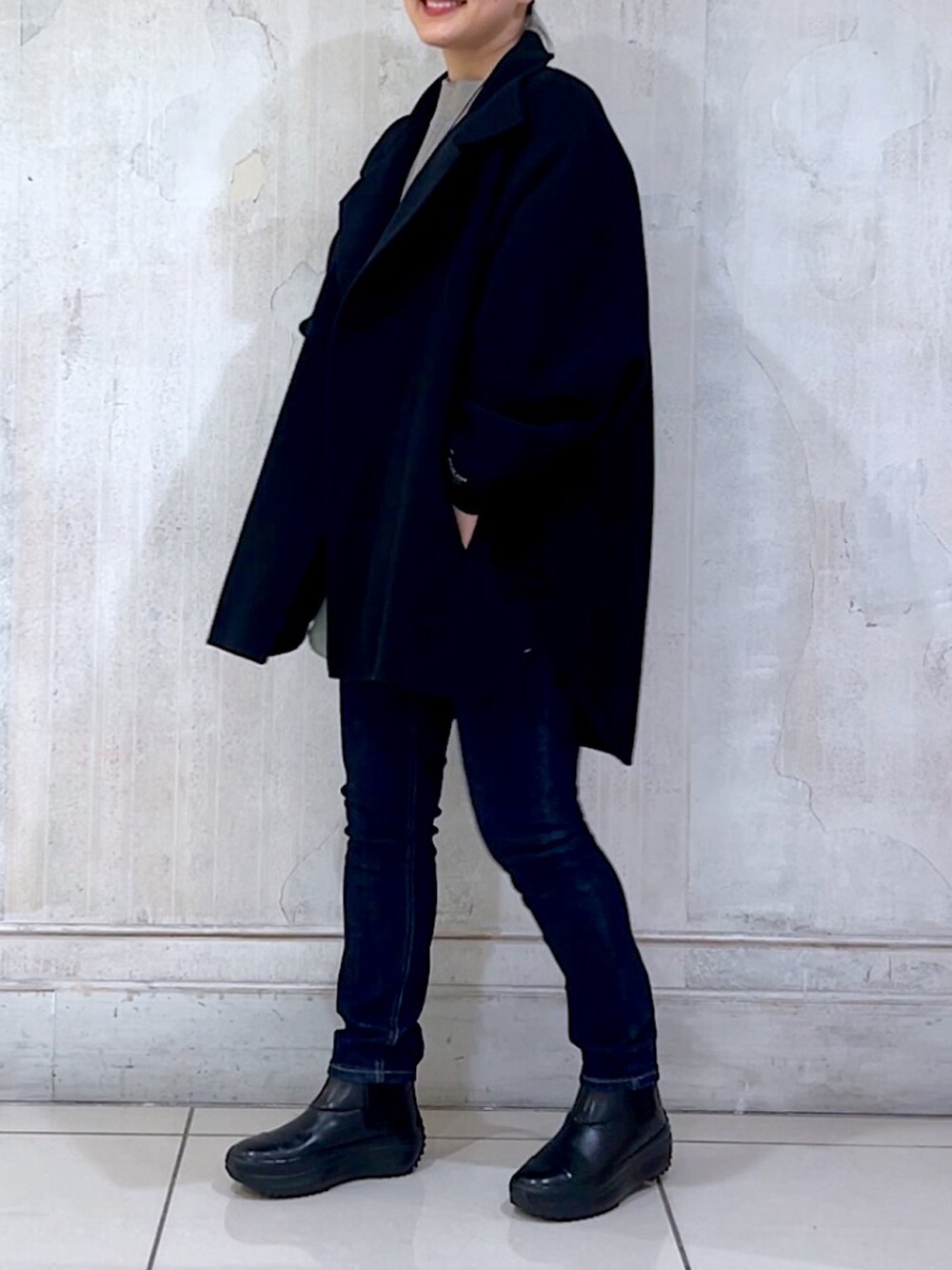 ブルー系のデニムパンツ、ブラック系のその他アウター、グレー系のニット/セーターを着用したレディースの秋コーディネートの4枚目の写真