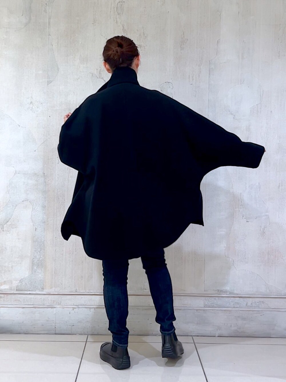 ブルー系のデニムパンツ、ブラック系のその他アウター、グレー系のニット/セーターを着用したレディースの秋コーディネートの2枚目の写真