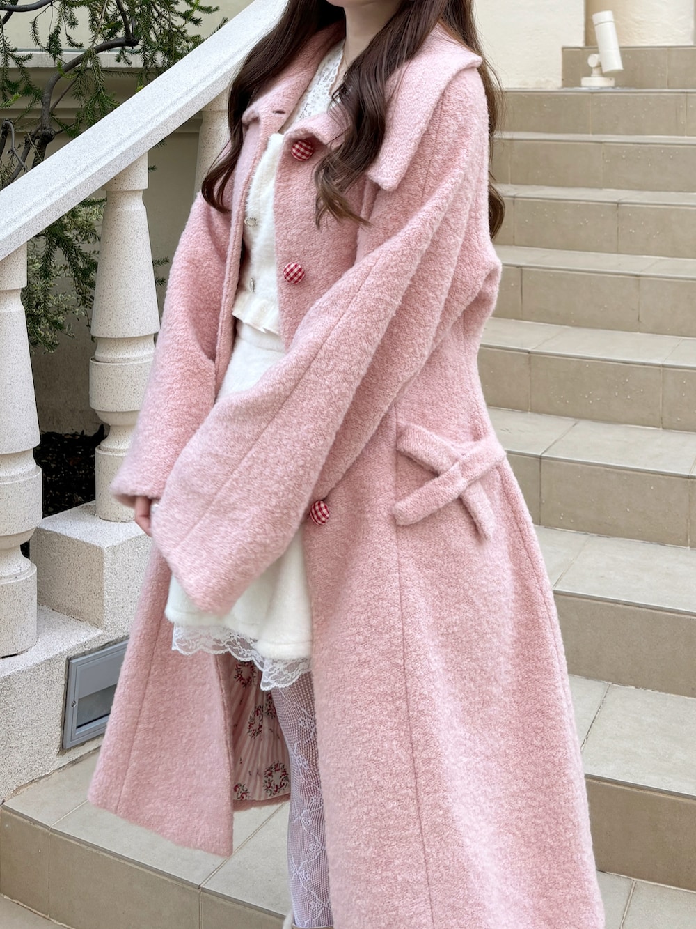 ピンク系のジャケット/アウター、ベージュ系のブーツ、ホワイト系のタイツ/ストッキングを着用したレディースの冬コーディネートの3枚目の写真