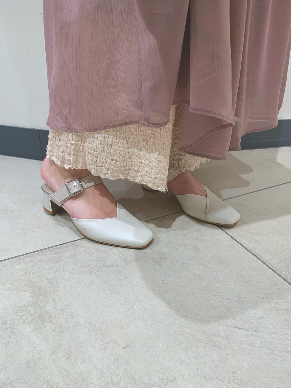 ホワイト系のショルダーバッグ、ホワイト系のパンプスを着用したレディースの春コーディネートの2枚目の写真