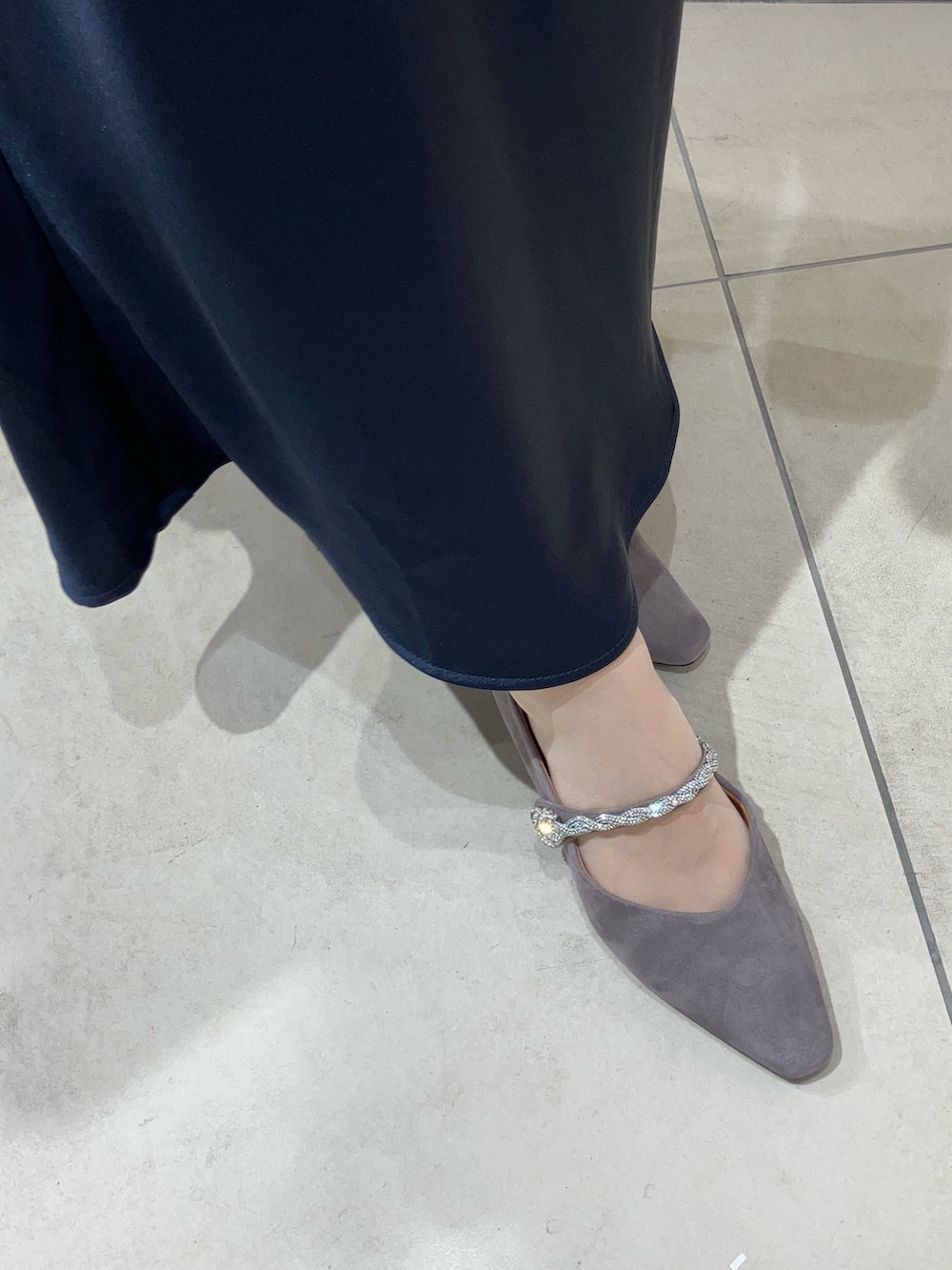 グレー系のパンプス、シルバー系のバッグを着用したレディースの秋コーディネートの3枚目の写真