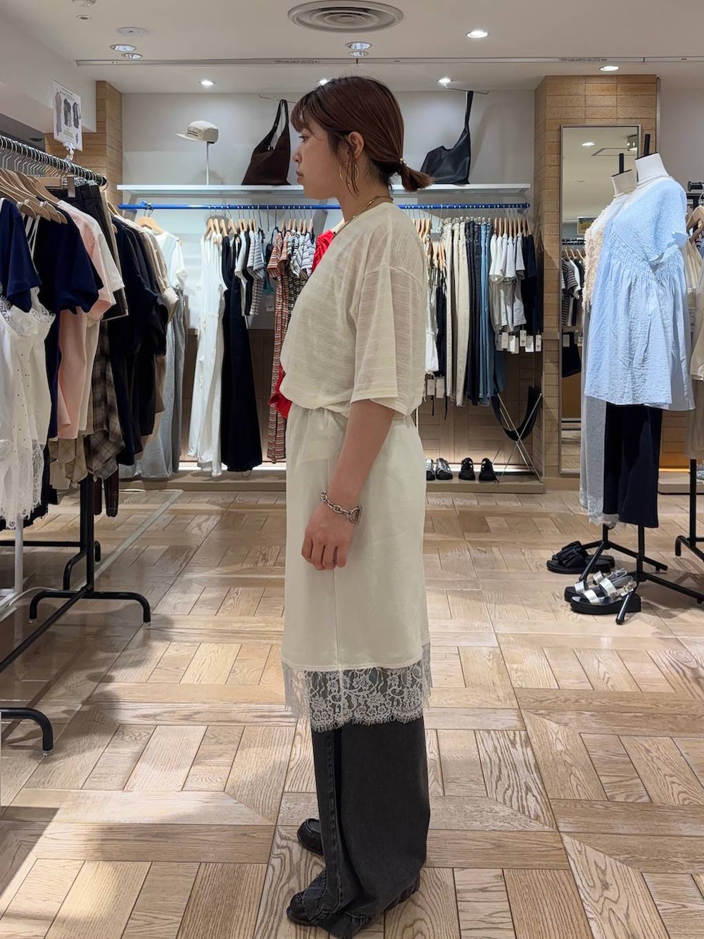 ブラック系のデニムパンツ、レッド系のボディバッグ/ウエストポーチ、ブラウン系のローファーを着用したレディースの春コーディネートの2枚目の写真